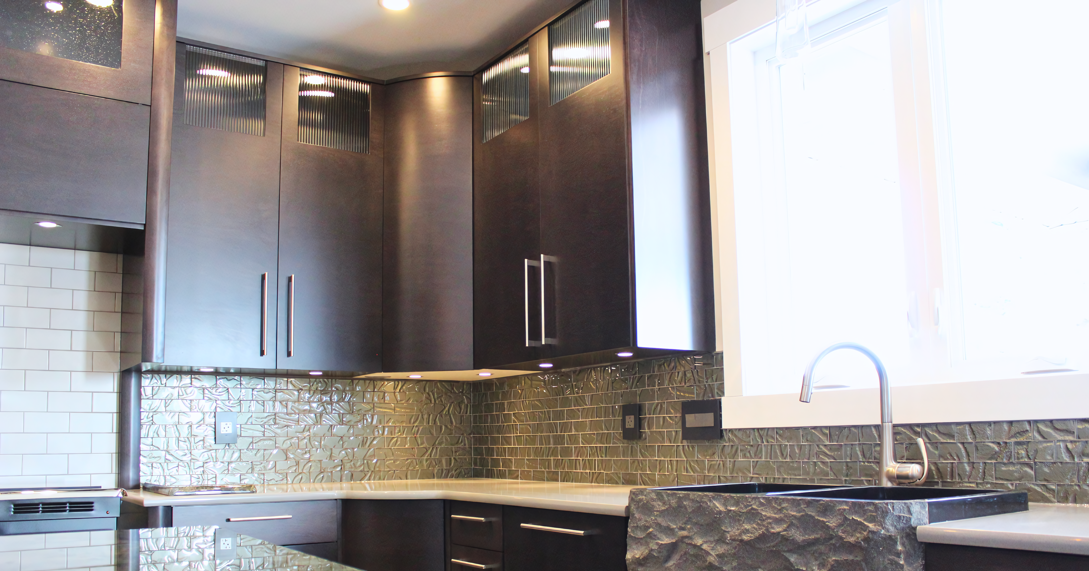 Kitchen corner upper cabinetry featuring integrated LED lighting and glass-front display inserts.