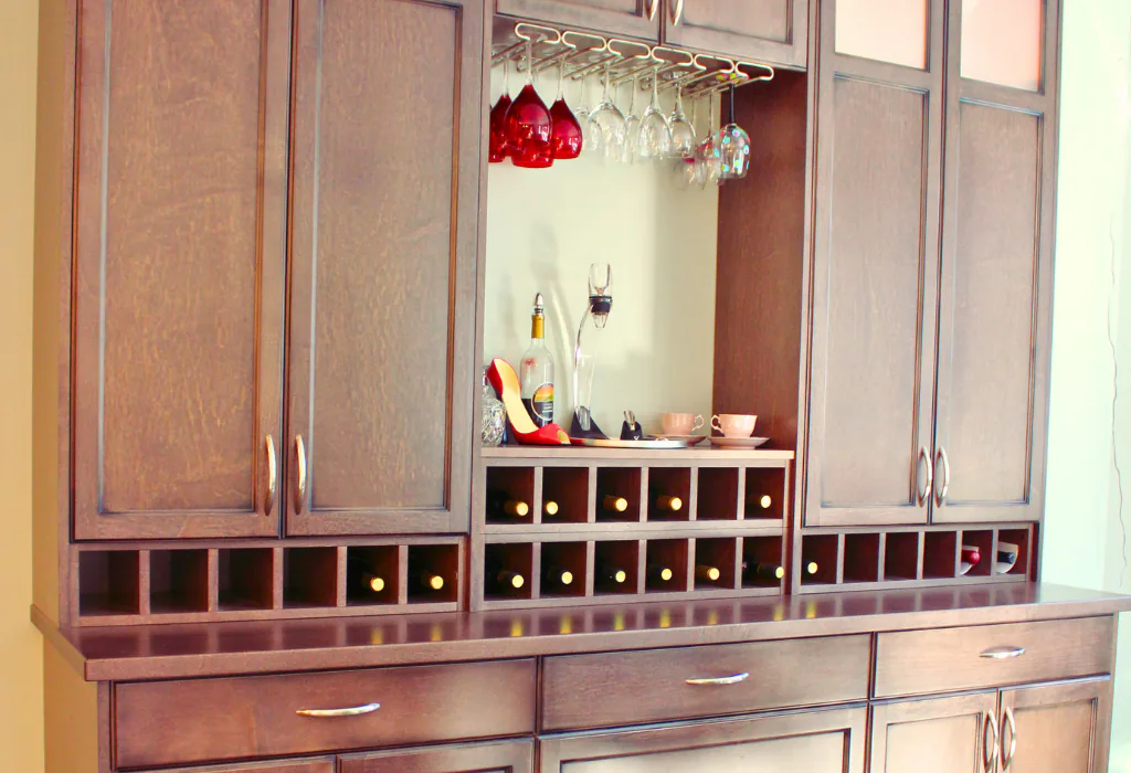 Custom espresso-stained wood home bar hutch featuring shaker cabinetry, integrated wine bottle cubby shelving, and an under-cabinet stemware rack.