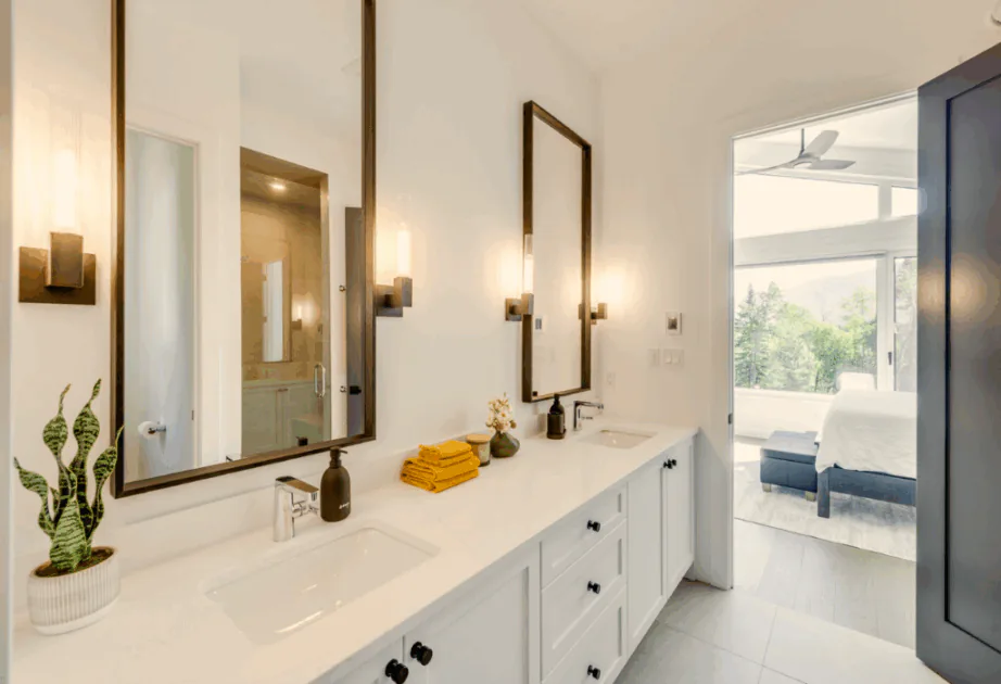 Contemporary double bathroom vanity featuring custom white shaker-style cabinetry, matte black hardware, and a seamless white quartz countertop with dual undermount sinks.