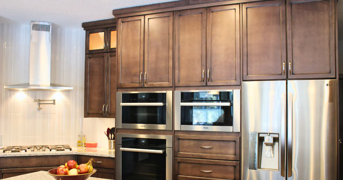 Dark espresso shaker-style floor-to-ceiling kitchen cabinets with a stainless steel professional wall oven stack and integrated French door refrigerator.